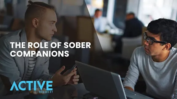 Two sober people talking while in front of a laptop