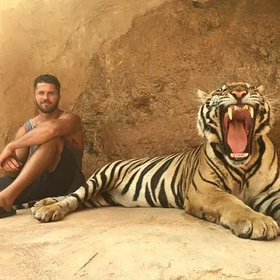 Active recovery founder Taylor Wilson sitting next to a tiger